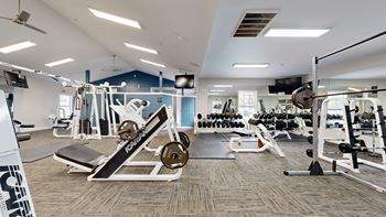 a gym with weights and cardio equipment in a building with blue walls